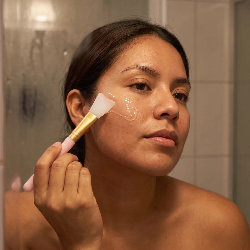 Mujer aplicándose el gel en la mejilla con la brocha de silicón